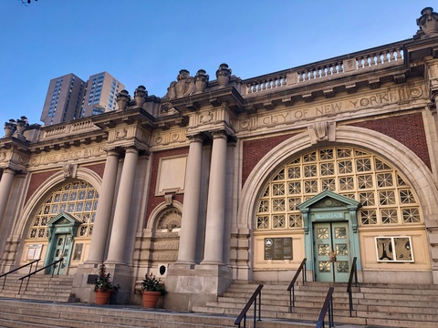 An iPhone photograph of the Asser Levy Public Baths’ facade. The entablature reads: FREE PUBLIC BATHS / CITY OF NEW YORK. There are two separate double door entrances. MEN is engraved above the door on the left and WOMEN on the right.