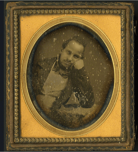 Framed daguerreotype portrait of Alexander Thomas leaning against a table while seated. Thomas is wearing a suit and bowtie. 