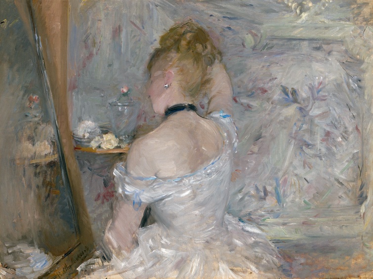 Painted in loose and rapid brushstrokes, a woman wearing a white dress sits in front of her mirror. She adjusts her hair which is in an updo. Flowers and a glass jar sit on a small table beside her.