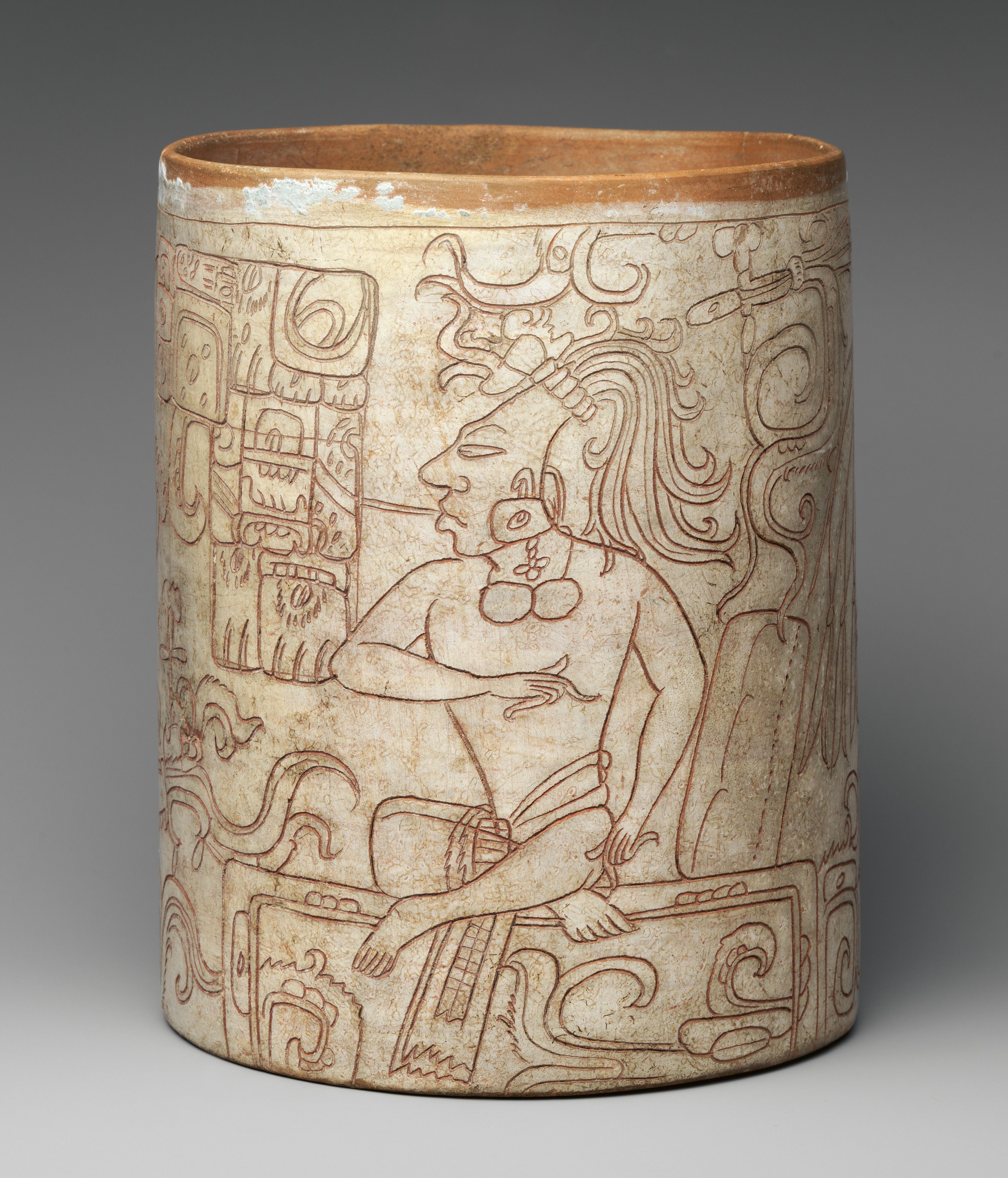 A cylindrical vessel with incised images of a Maya ruler and deity.